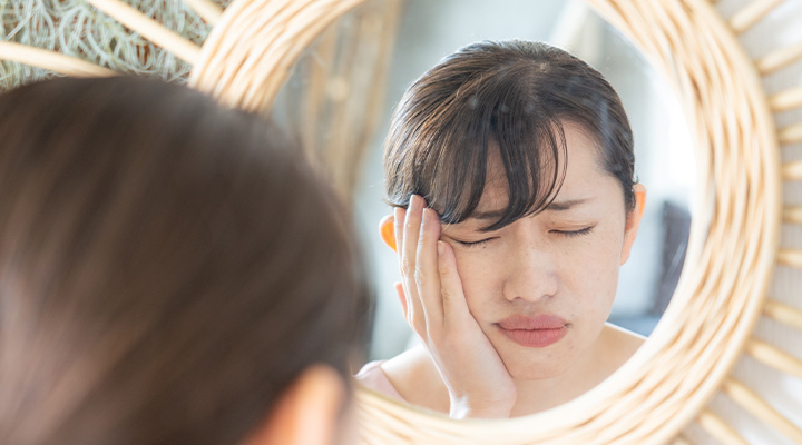 鏡を前に悩む女性