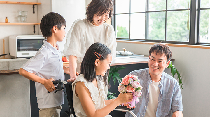 車いすに乗った少女と家族