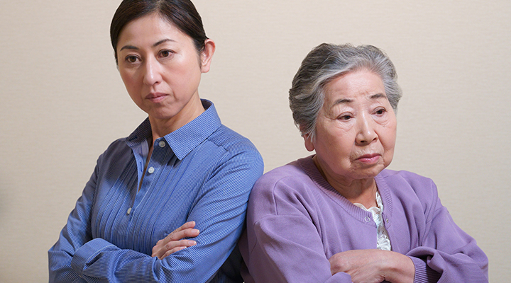 険しい表情の中年女性と老女