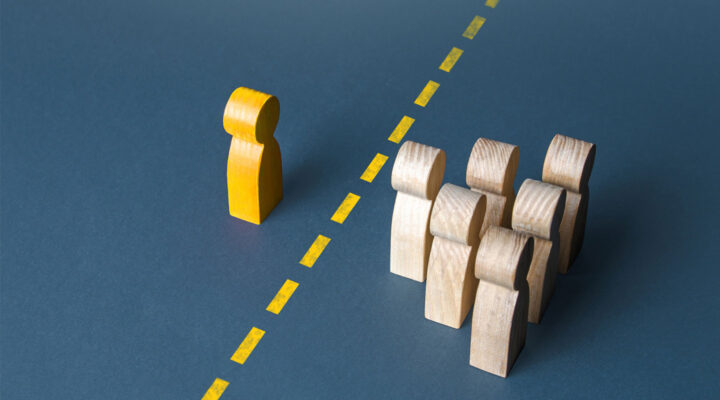 A person and a group of people are separated by a yellow line. Establishing contact. Distrust. Quarantine. Distance with strangers. Barrier to understanding, difficult integration. Rejection, refusal.