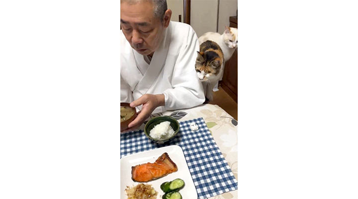 食事をとる栃木県・那須の長楽寺の住職と、寄り添う猫・ミー子